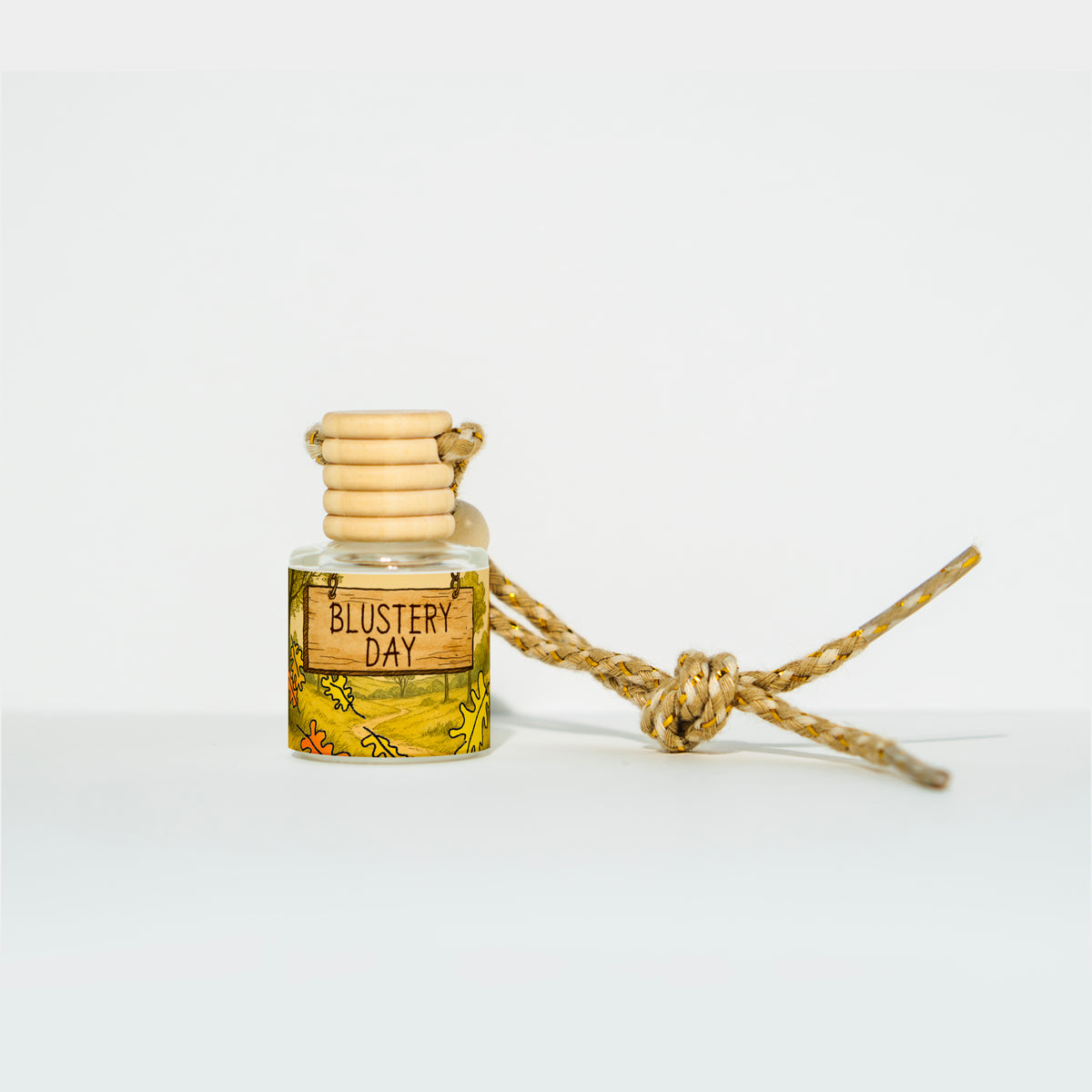 Trader Walt’s ‘Blustery Day’ car freshener inspired by the Winnie the Pooh storybook world, with autumn scents of dried leaves, clove buds, and birch. The Parks Collection label features a cozy, storybook-style forest design.