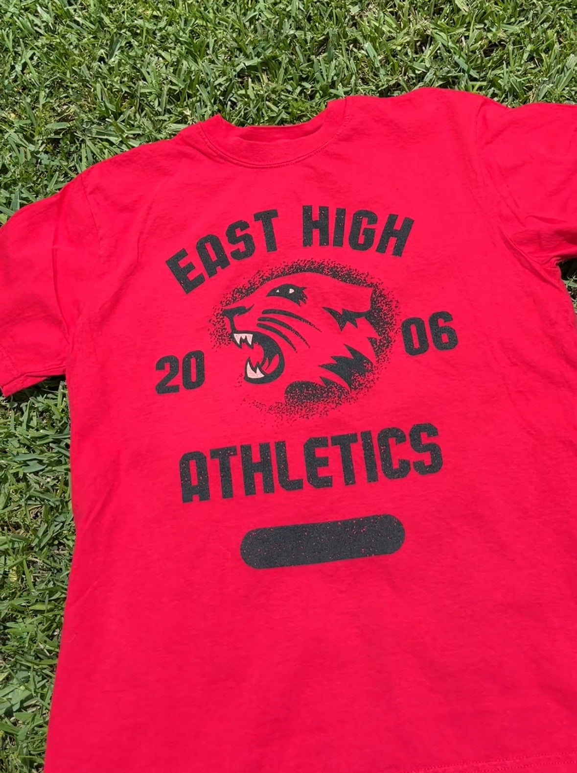 Red East High Athletics T-shirt with vintage Wildcats graphic inspired by High School Musical era.