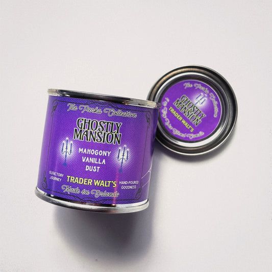 Ghostly Mansion purple tin candle by Trader Walt’s with Haunted Mansion–inspired design and mahogany, vanilla, and dust fragrance notes.