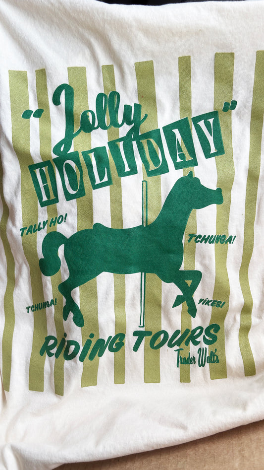 Vintage Jolly Holiday Riding Tours T-shirt with green carousel horse graphic and retro stripe background on cream cotton.