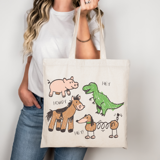 Toy Story inspired tote bag with crayon-style drawings of Rex, Hamm, Bullseye, and Slinky Dog on off-white cotton canvas